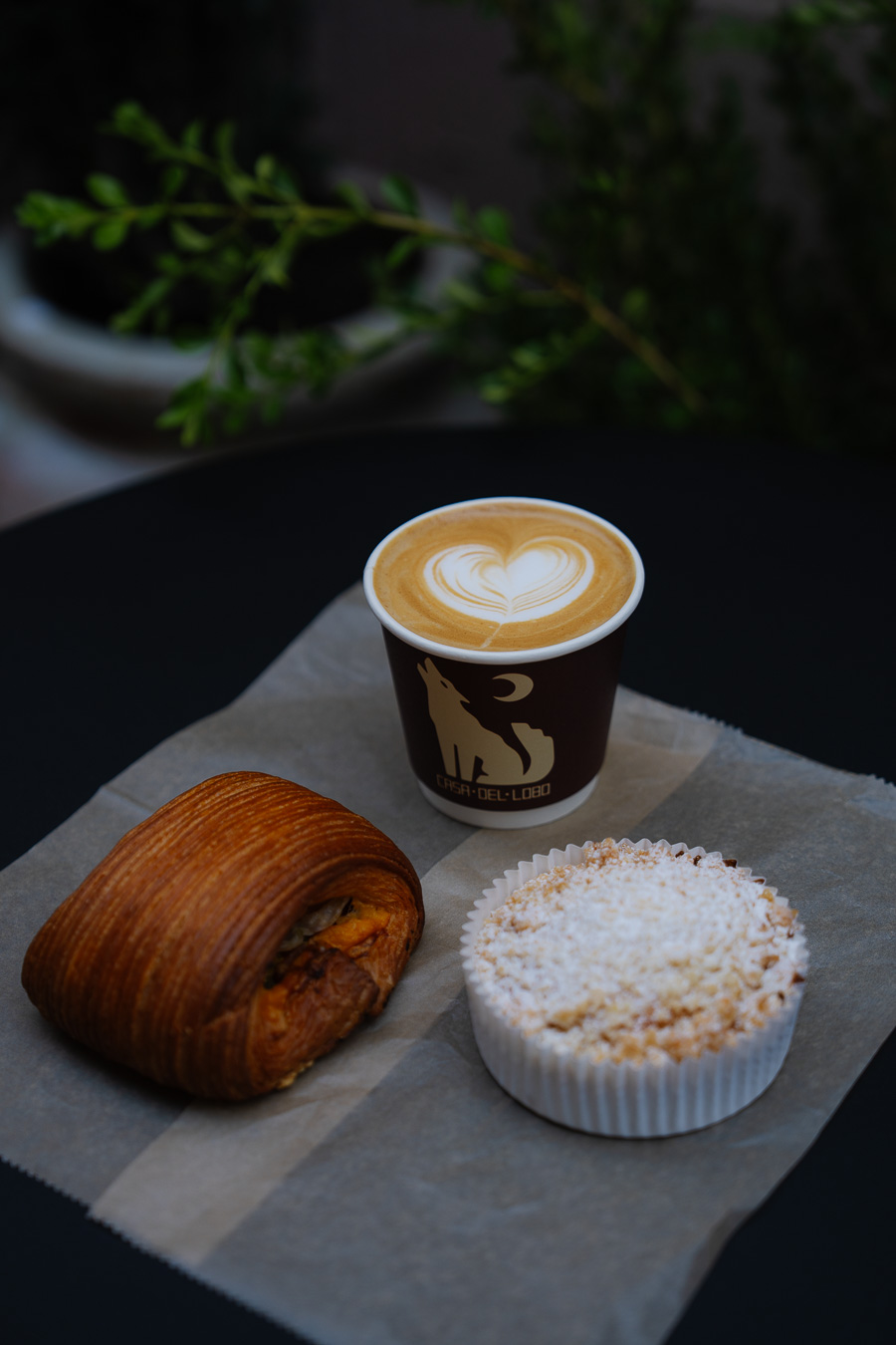 Latte with croissant and pastry on parchment paper
